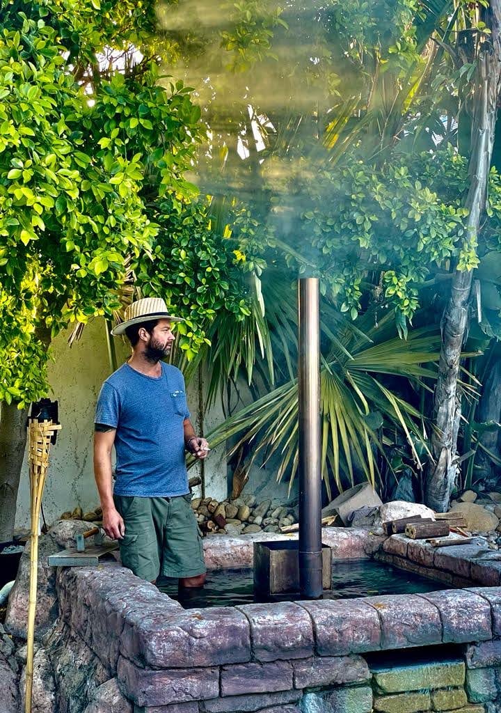 The wood-fired hot tub steaming among the trees